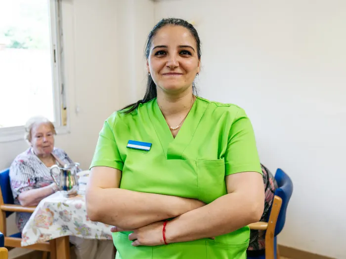 A support worker standing in a care home common room