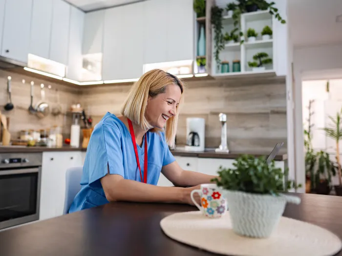A support worker at a kitchen table during a home visit
